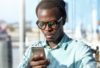 Indoor portrait of serious concentrated Afro American young man reading urgent text message on mobil