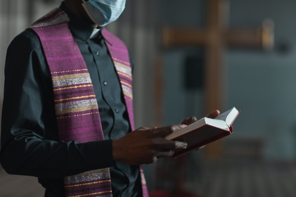 Priest with Bible in the church